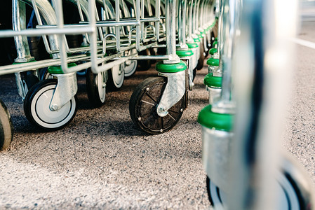 超市一排手推购物车塑料轮的细节特写图片