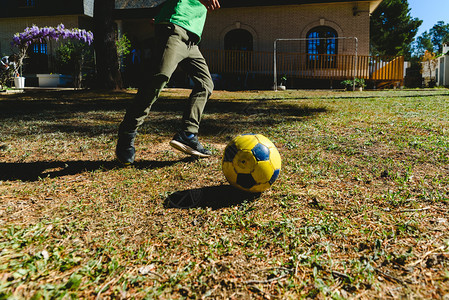 孩子在家院子里玩足球图片