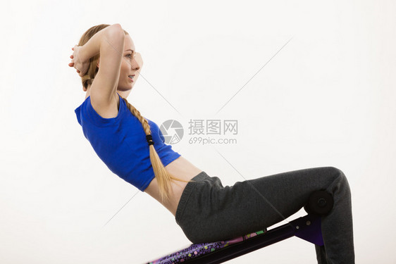 年轻少女在长椅上接受培训以便在家里坐下来身体健康胃肌肉锻炼图片