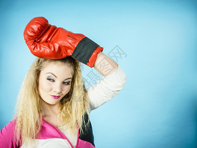 穿着红手套的有趣金发女孩拳击手 玩运动演播室 蓝射击穿着红手套的有趣女孩玩运动拳击背景图片