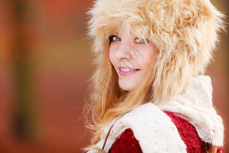 美丽的年轻女孩穿着毛皮冬帽和衣脱秋天时尚穿着毛皮冬帽的漂亮微笑女肖像图片