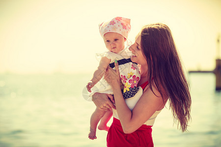 暑假家庭娱乐概念母亲在夏季与婴儿一起在海滩上玩耍母亲与婴儿一起在海滩玩耍图片