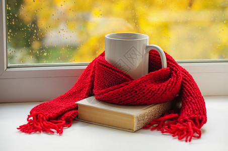 红色喜庆背景秋天生命温暖的围巾和茶杯靠近窗户复制空间背景