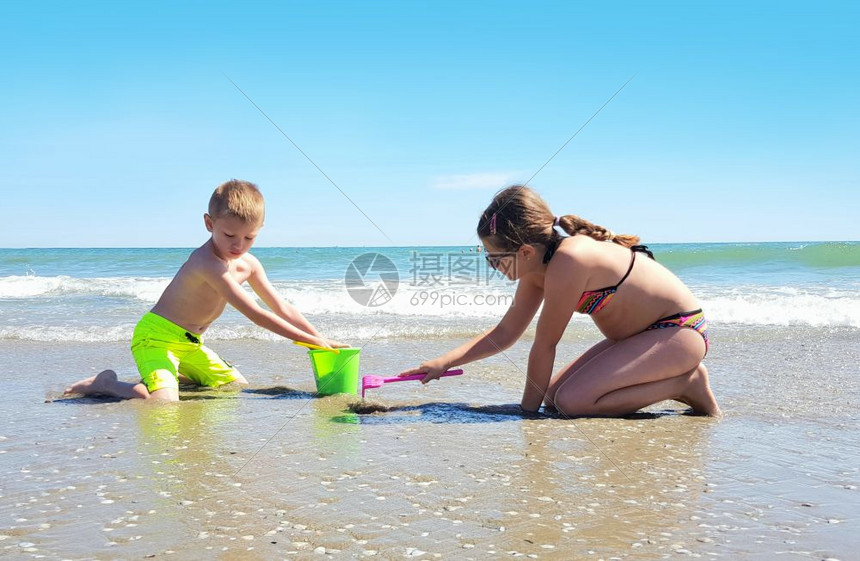 两个孩子在岸边玩耍阳光明媚图片