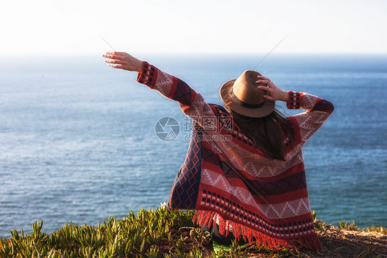 穿着旅行服和帽子坐着看蓝色的海洋和天空旅行概念照片穿旅行服和帽子坐着看蓝色的海洋和天空图片