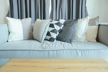 灰色沙发上时髦的枕头客厅里有木桌图片