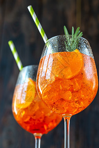 AperolSpritz鸡尾酒玻璃杯在生锈背景上图片