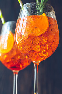 AperolSpritz鸡尾酒玻璃杯在生锈背景上图片