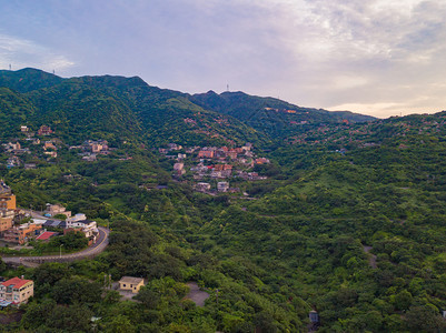 对新北市农村地区山丘上的Jiufen村建筑物和天然绿林的空中观察图片