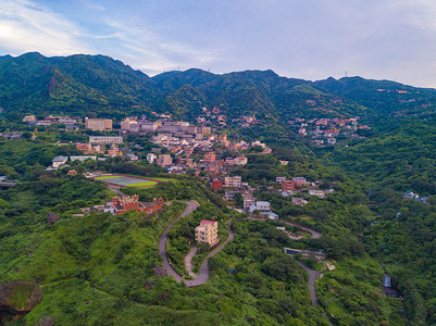 对新北市农村地区山丘上的Jiufen村建筑物和天然绿林的空中观察图片