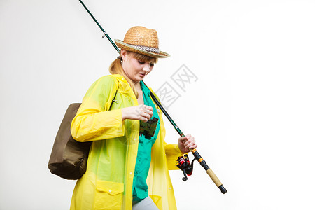 穿雨衣的妇女拿着鱼棒准备冒险图片