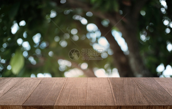 在餐厅的抽象模糊布基背景面前的空暗黑木桌可以用于显示或蒙合您的产品图片