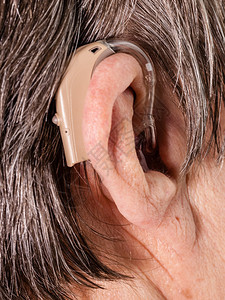 保健听力放大聋人设备使用助听器的高级妇女图片