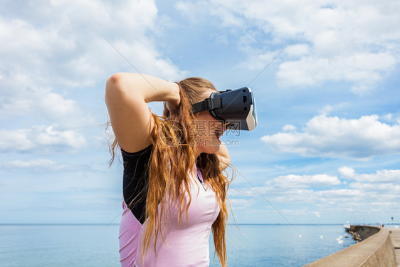 女青年在外测试VR眼镜女青年在夏季天气中佩戴虚拟现实头巾图片