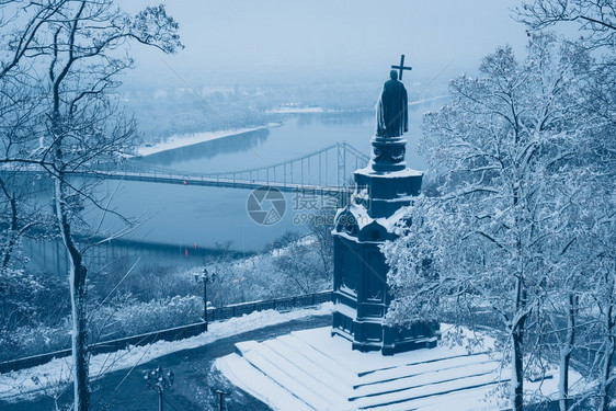 基辅圣沃洛季米尔冬的白化青铜雕像底的冷冻Dnieper河和足桥图片