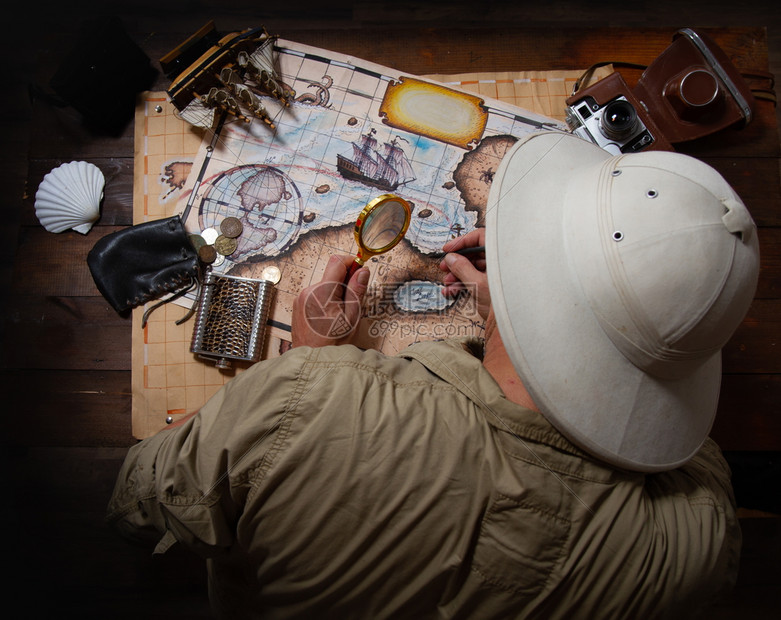 在一个旧木制桌子上戴软头盔的成人探险家使用旧铺路