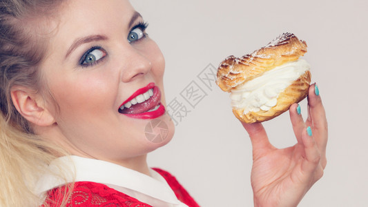甜食和快乐的概念有趣快乐金发女人拿着美味巧克力蛋糕和奶油图片