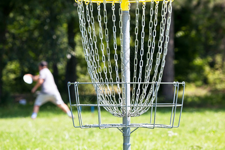 男人在公园里扔飞盘打圆高尔夫球图片