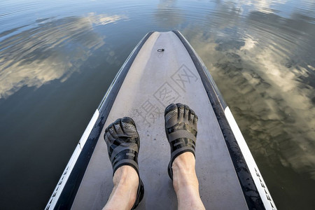 男人脚在五指水鞋上站在桨板图片