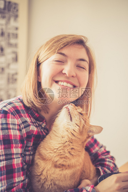 红小猫在亲吻一个年轻漂亮的女孩特写图片