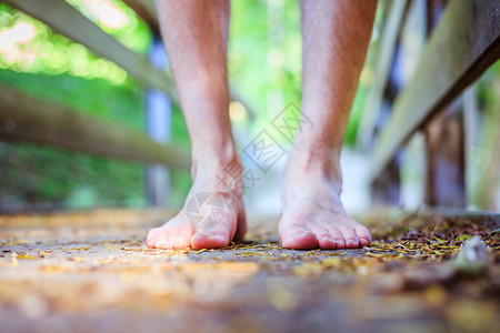 赤脚踏在森林里一个生锈的老木桥上冒险图片
