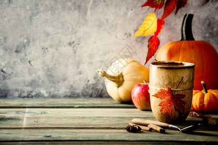 秋幕背景茶杯或咖啡南瓜派香料和木制餐桌边的叶子以对抗古老的生锈状况墙壁文字空间图片