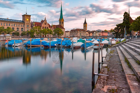 著名的Fraumunster圣彼得教堂和在瑞士最大城市苏黎世老Limmat河清晨蓝色时分在Limmat河沉思的船只苏黎世瑞士最大图片