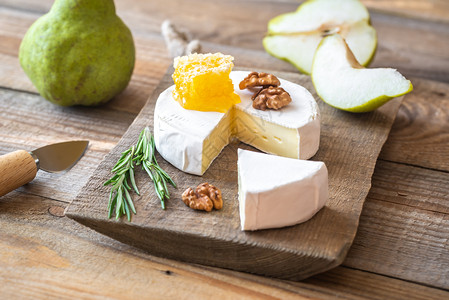 梨块木板上含新鲜梨子和胡桃的咖啡奶酪背景