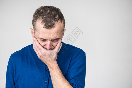 忧郁悲伤焦虑的成年男子蒙住嘴感到内疚和羞愧图片