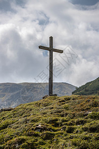 在奥地利山上用木顶峰十字顶背景图片
