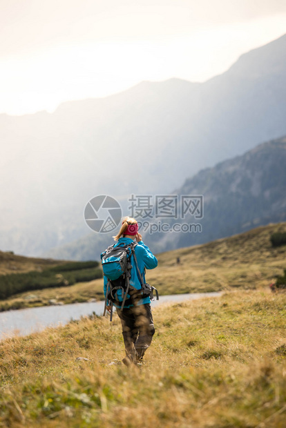 职业运动穿服的妇女正在山上徒步旅行奥地利图片