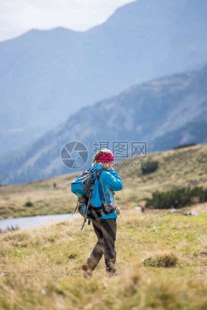 职业运动穿服的妇女正在山上徒步旅行奥地利图片