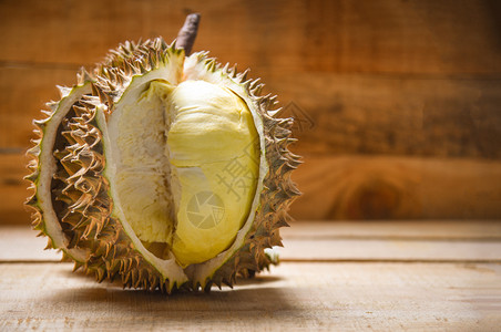 夏季Durian在木制背景料上撕扯新鲜的durian剥削热带水果背景图片