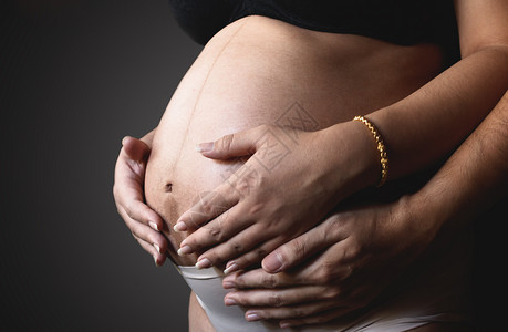 孕妇的手和丈夫拥抱肚子图片