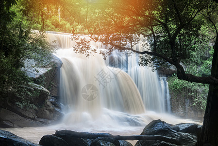 美丽的瀑布景观山上河流中阳光照耀山上有树和岩石地表瀑布塔伊兰热带森林图片