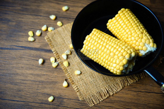 玉米在锅上烹饪甜玉米耳朵在木制背景关闭图片