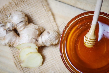 蜂蜜在罐子里糖加蜂和姜汁在麻袋木桌背景的制餐图片