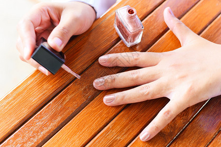 女手用指甲油女手用指甲油女手和木制涂漆图片
