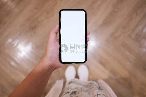 妇女手握机电话空白复制间屏幕有技术概念的智能电话图片