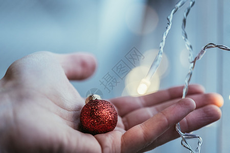 手握着一个小红的圣诞酒杯闪发光的背景图片