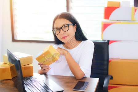 在线销售网上电子商务航运网上购物交付和订启动小企业主工作概念年轻妇女在交付时向客户运送现金包装纸板箱裹图片