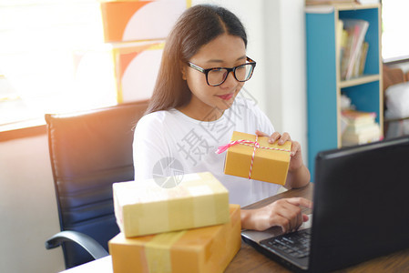 在线销售网上电子商务航运网上购物交付和订启动小企业主工作概念年轻妇女在交付时向客户运送现金包装纸板箱裹图片