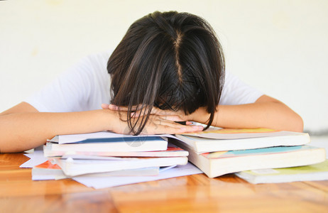 在课堂上学习笔记并使用铅时学习概念的年轻女子学院要求生参加考试决赛并睡在书本上图片