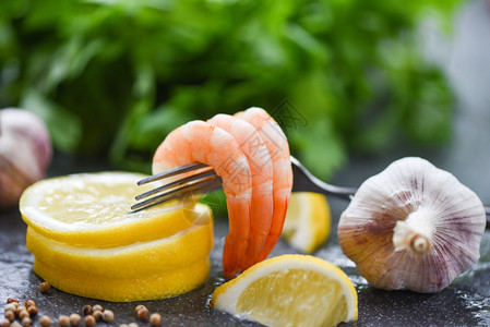 餐盘上桌的叉面新鲜虾海产食品煮熟的虾时配有香料柠檬大蒜和深底蔬菜沙拉生图片