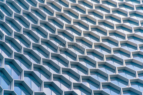 办公室建筑未来技术网络连接概念中六边形窗口的结构蓝玻璃现代建筑设计外观反映市区中心的天空图片