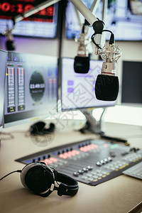 广播电台演室混音器和模糊背景计算机的演播室麦克风图片