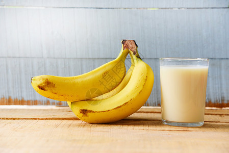 含香蕉水果和以木制的玻璃牛奶和香蕉果制品的健康食图片