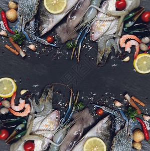 混合海产食品板和壳鱼虾蟹鱿鱼章和的海洋美食晚餐带草药的新鲜生海菜和深底柠檬香料背景图片