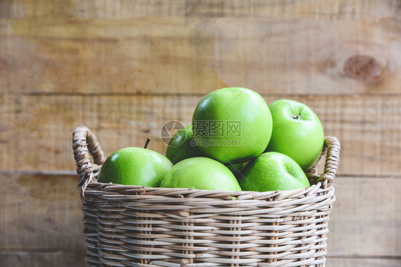 绿苹果木本底篮子中的收获苹果图片