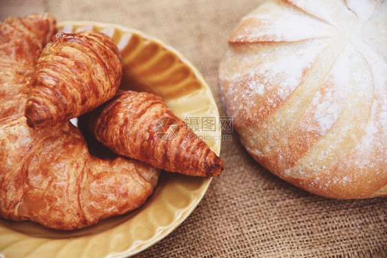 新鲜烤面包羊角餐桌上的面包土制早餐食品概念图片